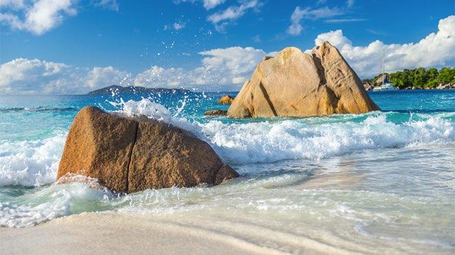praslin island rocks on white sandy beach