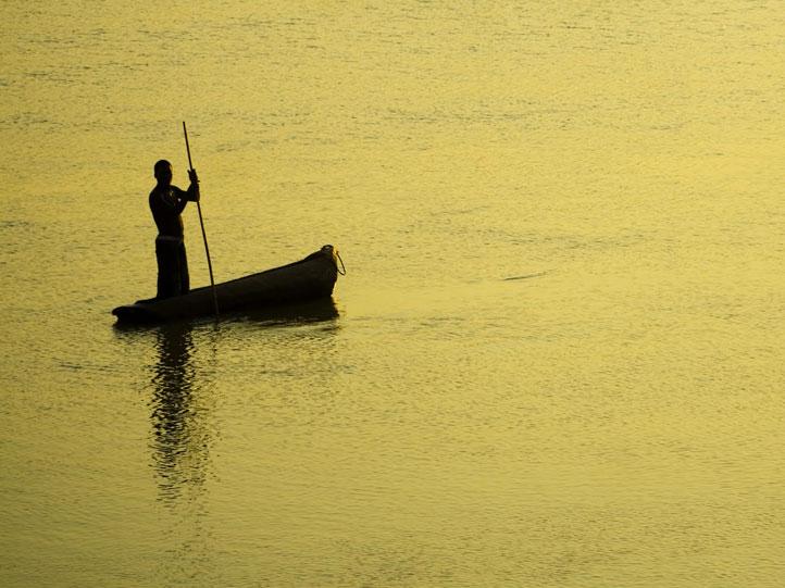 zambia fisherman in traditional canoe on calm waters
